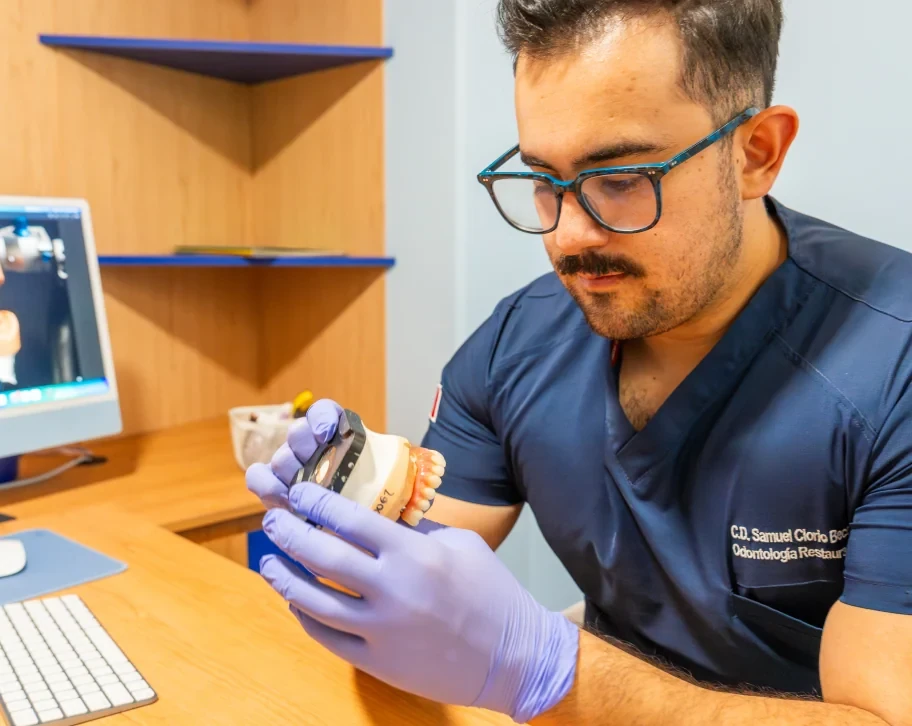 Dr. Samuel Clorio reviewing a full-arch implant model for All-on-6 prosthetic planning at hisonrisa in Roma Sur, Mexico City.