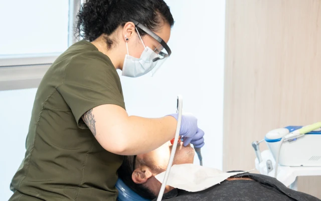 A hisonrisa clinician provides dental care to a patient in the treatment chair.