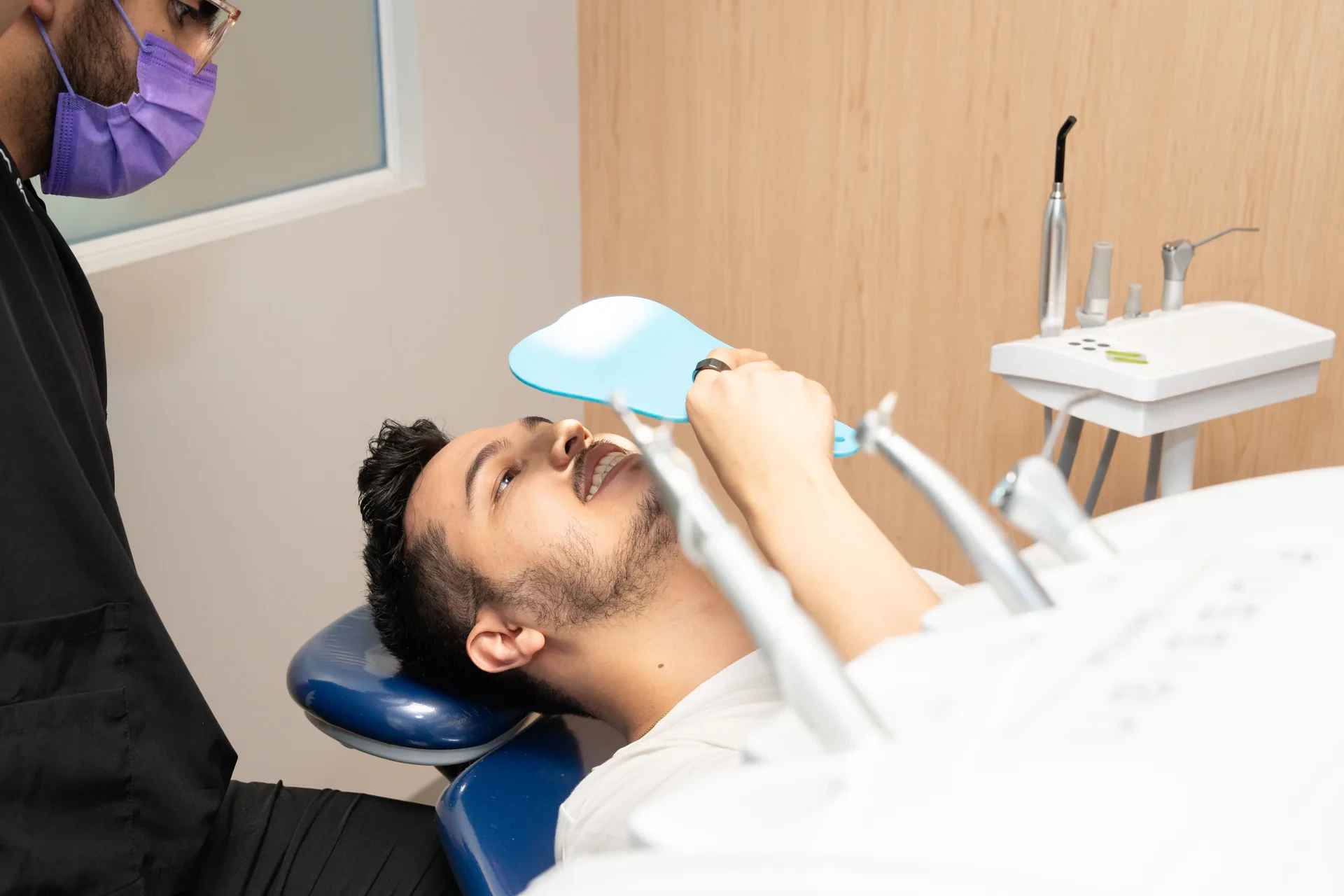 A patient uses a hand mirror during a chairside dental review at hisonrisa.