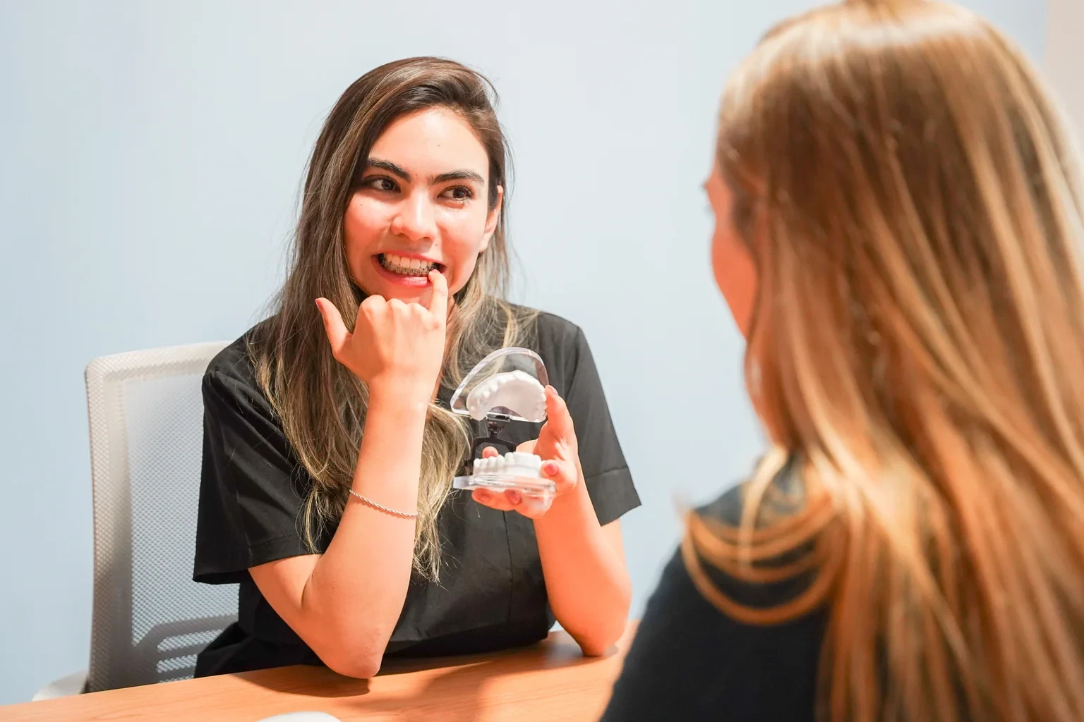 Dentista explicando opciones con un modelo dental durante una consulta en hisonrisa.