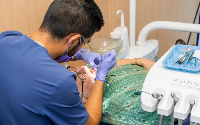 Dentist treating a patient during a restorative dental visit at hisonrisa in Roma Sur, Mexico City.