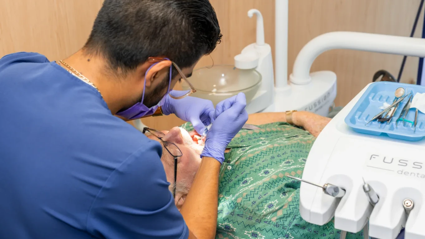 Dentist treating a patient during a restorative dental visit at hisonrisa in Roma Sur, Mexico City.