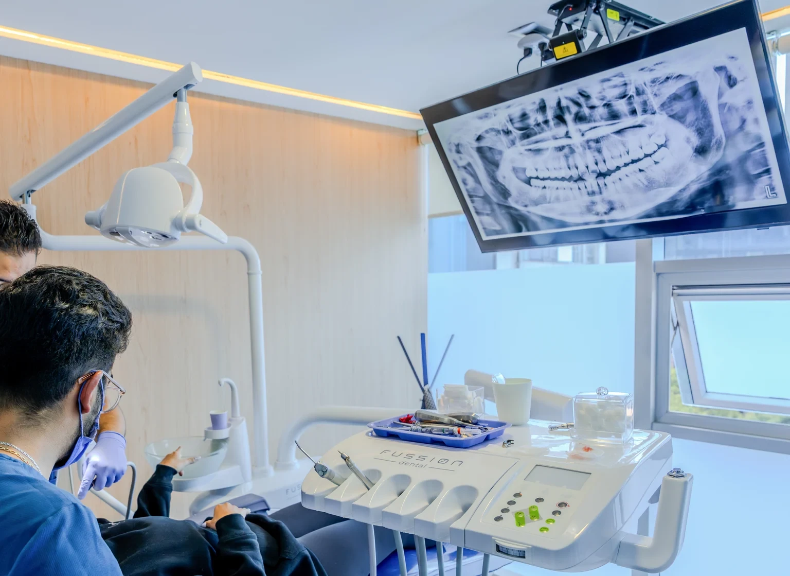 Paciente revisando una pantalla dental durante una consulta antes de elegir el material de una corona.
