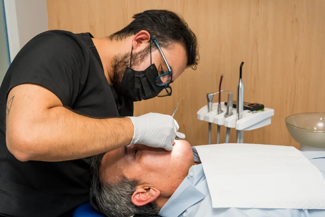 Dentist in white gloves treating a patient during a crown visit at hisonrisa in Mexico City.
