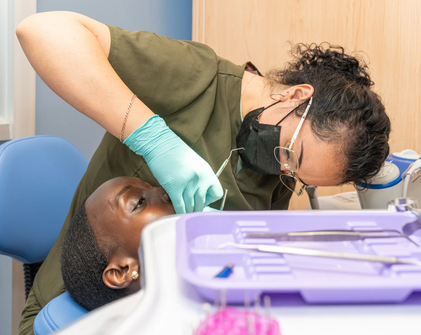 Dentist checking a patient's teeth during a dental exam at hisonrisa in Roma Sur, Mexico City.