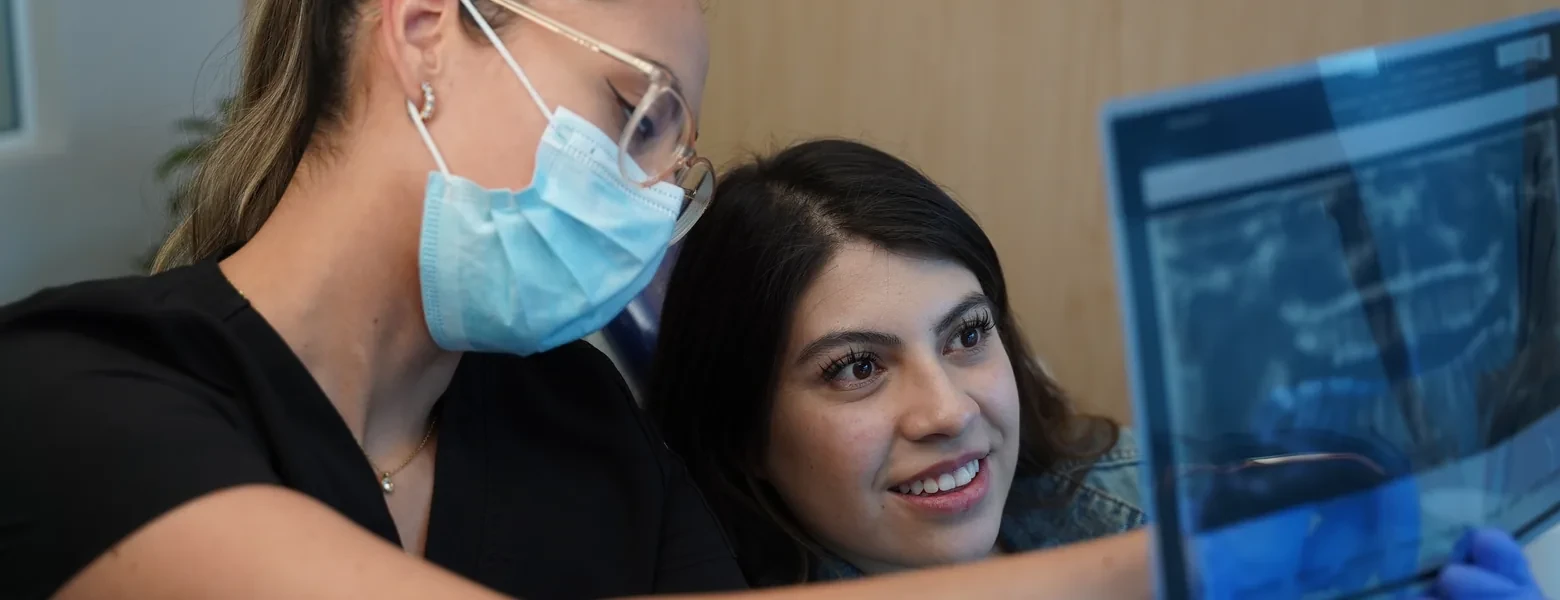 Dentist and patient reviewing a panoramic X-ray at hisonrisa in Mexico City.
