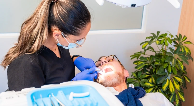 Dentist checking a patient's smile before planning a removable partial denture.