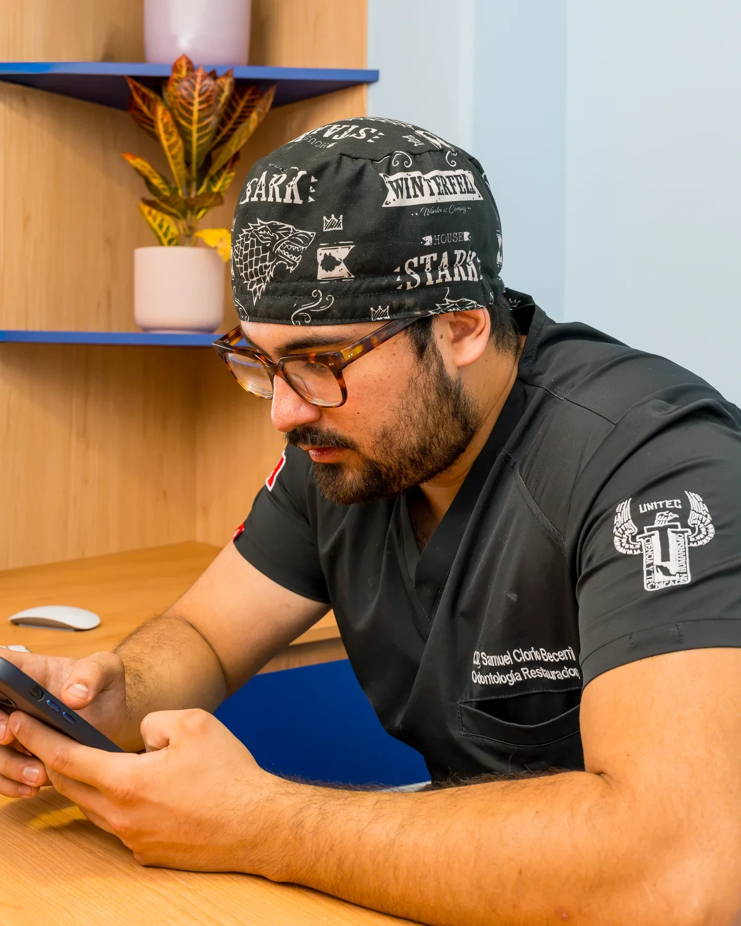 hisonrisa dentist reviewing patient records on a phone before planning treatment in Roma Sur, Mexico City.