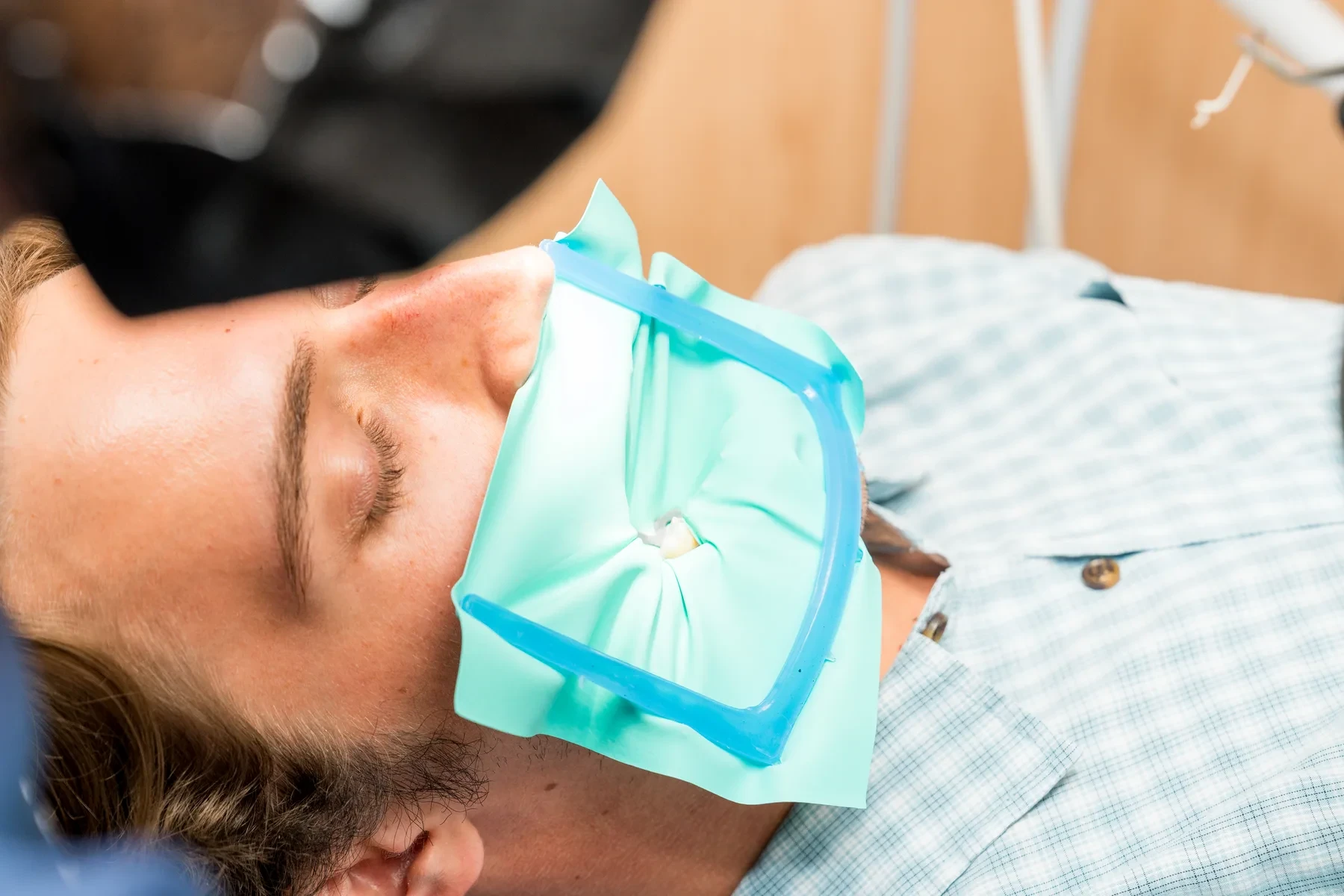 Patient under rubber-dam isolation during restorative treatment at hisonrisa in Roma Sur, Mexico City.