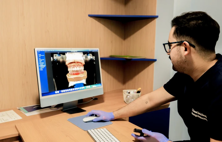 Dentista de hisonrisa revisando un modelo dental digital para planear un tratamiento restaurativo en Ciudad de México.